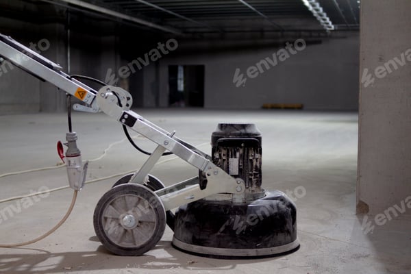 Bodenschleifmaschine auf rohem Betonboden in einem Rohbau