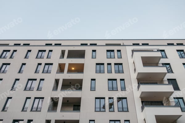 Helle Fassade eines mehrgeschossigen Wohnhauses mit Balkonen